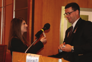 A guest at the meeting pulls a Ace to win a $50 prize.