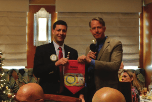 Russ Swain presents President Dave with a banner sent by a previous guest from China.