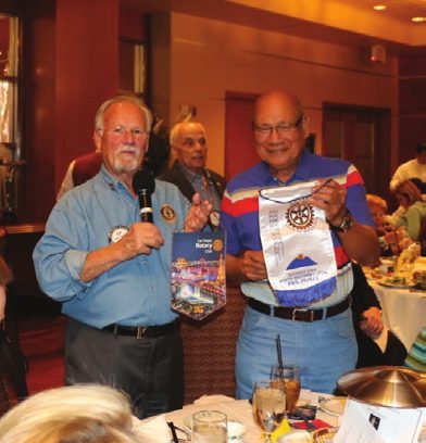 Bob Werner exchanges banners with an international Rotary member from the Philippines.