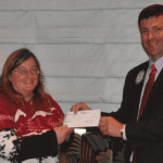 President Dave presents check to Barbara of New Horizons.