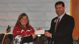 President Dave presents check to Barbara of New Horizons.