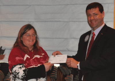 President Dave presents check to Barbara of New Horizons.