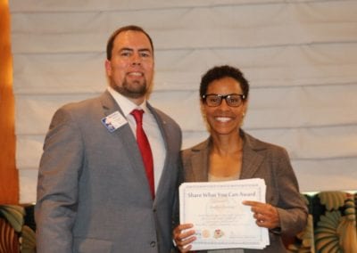 President Michael presents our speaker Joselyn Counsins of the Federal Reserve Bank with a Share What You Can Award.
