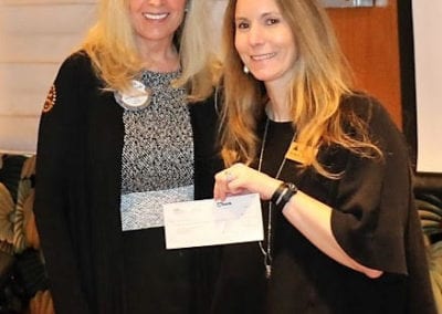 PE Jackie Thornhill presented a Community Grant check in the sum of $2,571.80 to Michelle Johnson of Junior Achievement. Michelle presented Jackie with a painting from her students.